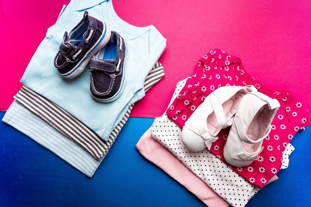 Folded blue and pink baby bodysuits clothing.