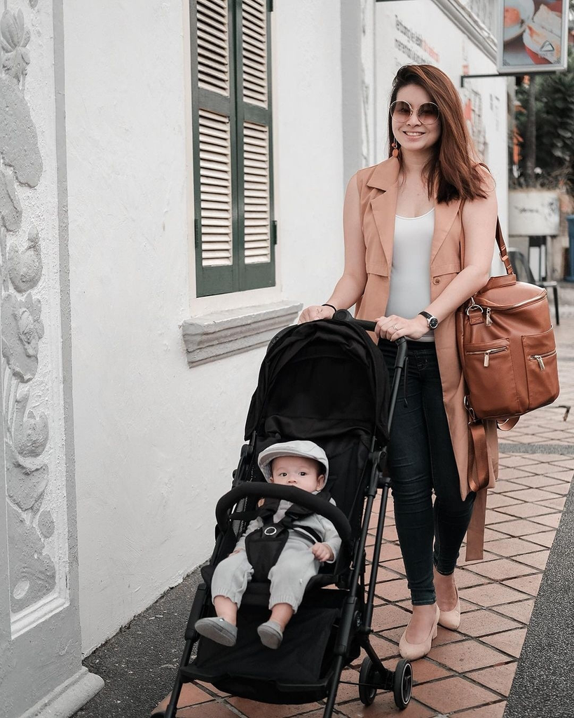 A mother pushing her baby boy in a stroller - change to another stroller brand that mothercare carries