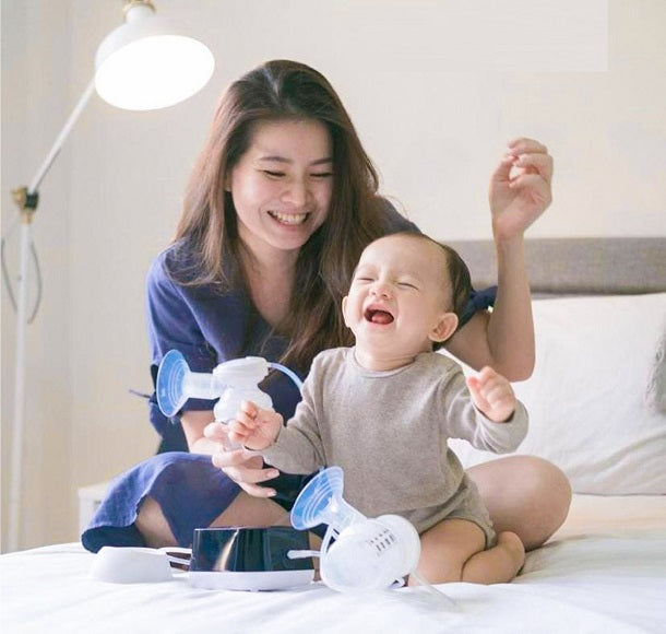 Happy mother and baby with breast pump