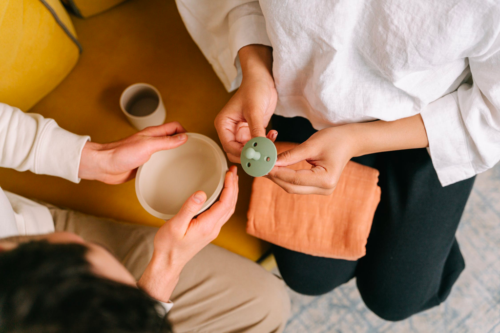 A woman is holding a green soother