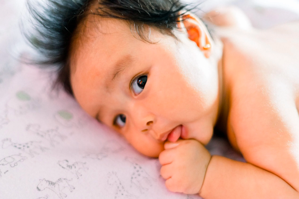 Adorable baby licking his thumb