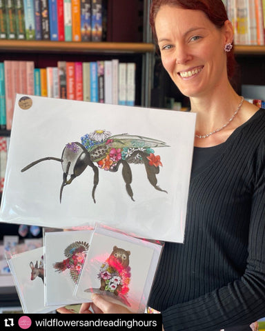 Woman holding artwork of a bee covered in flowers