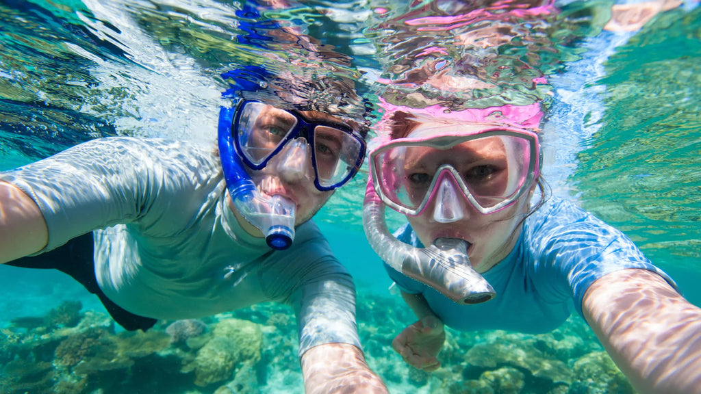 man and girl snorkeling underwater