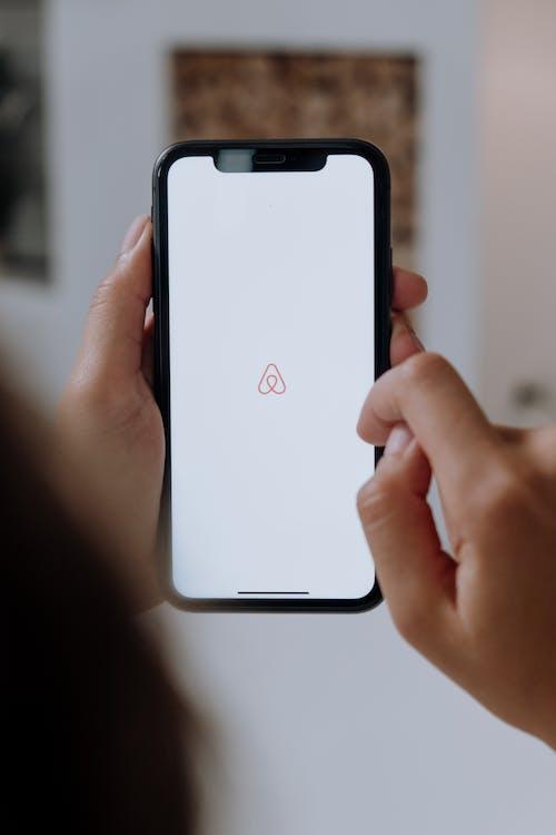 fingers on phone activating Airbnb app