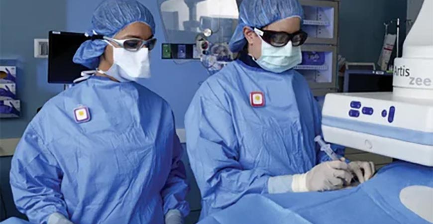 Two interventional radiologists work on a patient