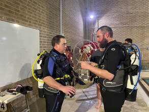 Tim and Ben thinking about how to demonstrate a skill as part of their Divemaster Preparation