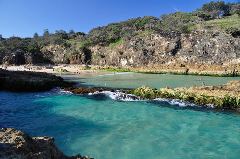 In an adventure day, jump & swim at the beach surrounded by mountains at North Stradbroke Island.