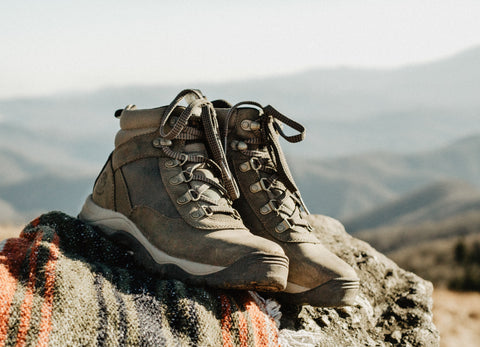 Faded brown, high-cut boots with white midsole, checkered shoe-lace, and black lining. Best for hiking.
