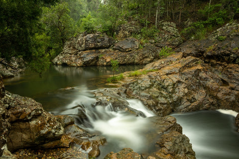 Jump for a bath on the Rocky Hole waterfall in D'Aguilar Range National Park after a muddy 4x4 tour.