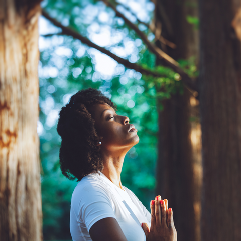 woman in the forest tree meditation pray hands together heart