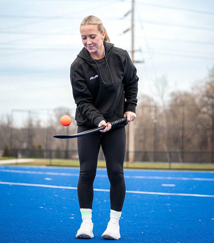 Field hockey player, Phia, bouncing a ball on a stick.