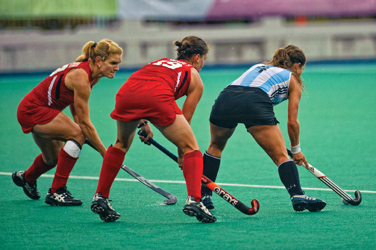 Side view of a Caucasian female field hockey player, during a