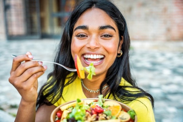 Woman eating healthy food and smiling