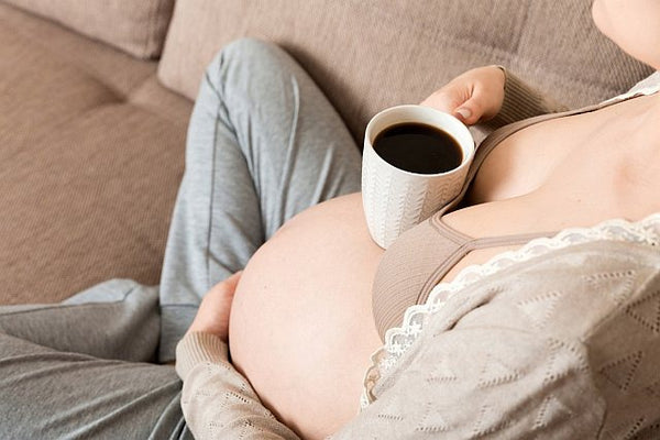 pregnant woman drinking black coffee