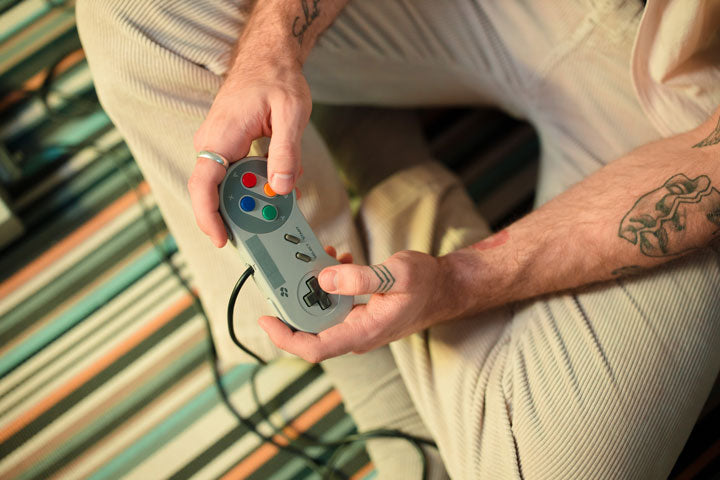 men play game with retro game controller at home