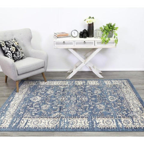 Distressed traditional blue rug under chair- Rugs Direct