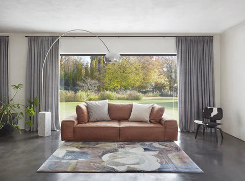  Large leather couch paired with floral rug design