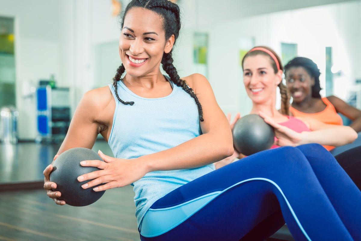 Happy women exercising in a class, cycle syncing her workout