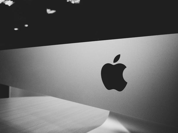 Apple logo behind laptop
