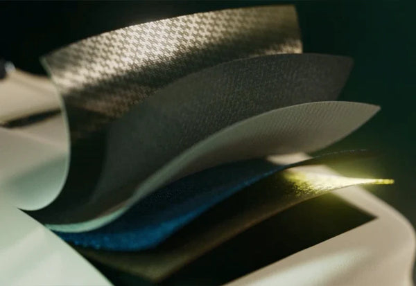 Close-up view of the HJC RPHA 60 Premium Integrated Matrix (PIM) shell construction, showing multiple composite layers including carbon fibre, aramid and hybrid materials for lightweight strength and impact protection