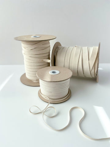 Group of elastic of various sizes on cardboard spools