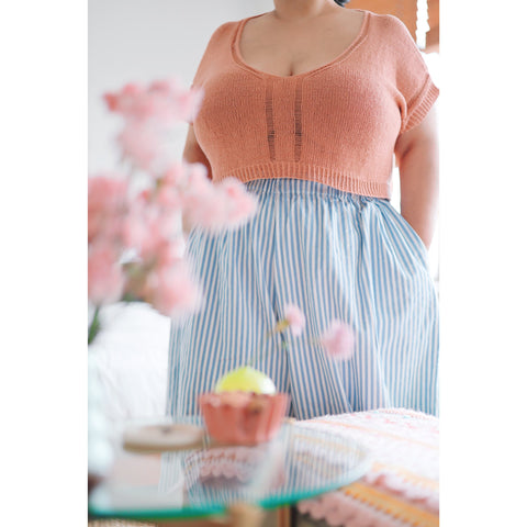 Peach coloured knitted v-neck top with decorative neckline on a plus sized model