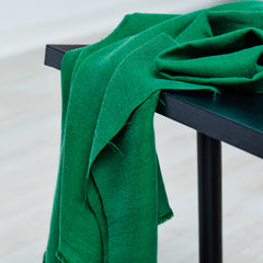 Woven sewing fabric draped over table in frog green colour