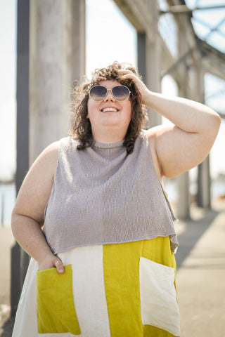 Plus sized Caucasian women wearing knitted tank, smiling looking up at the sun