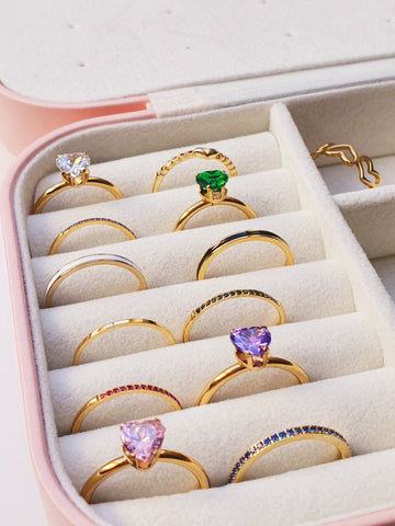Jewellery box filled with an assortment of gold rings with various gem styles and colours