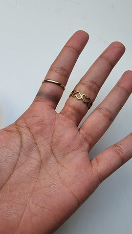 Hand wearing two gold rings pushed up slightly on the fingers to show that one has left staining and the other hasn't
