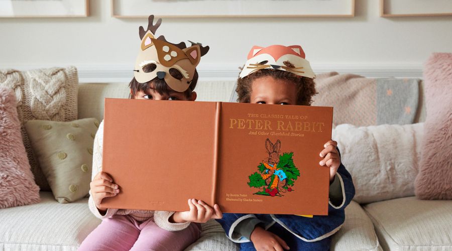 Children reading a book on a couch