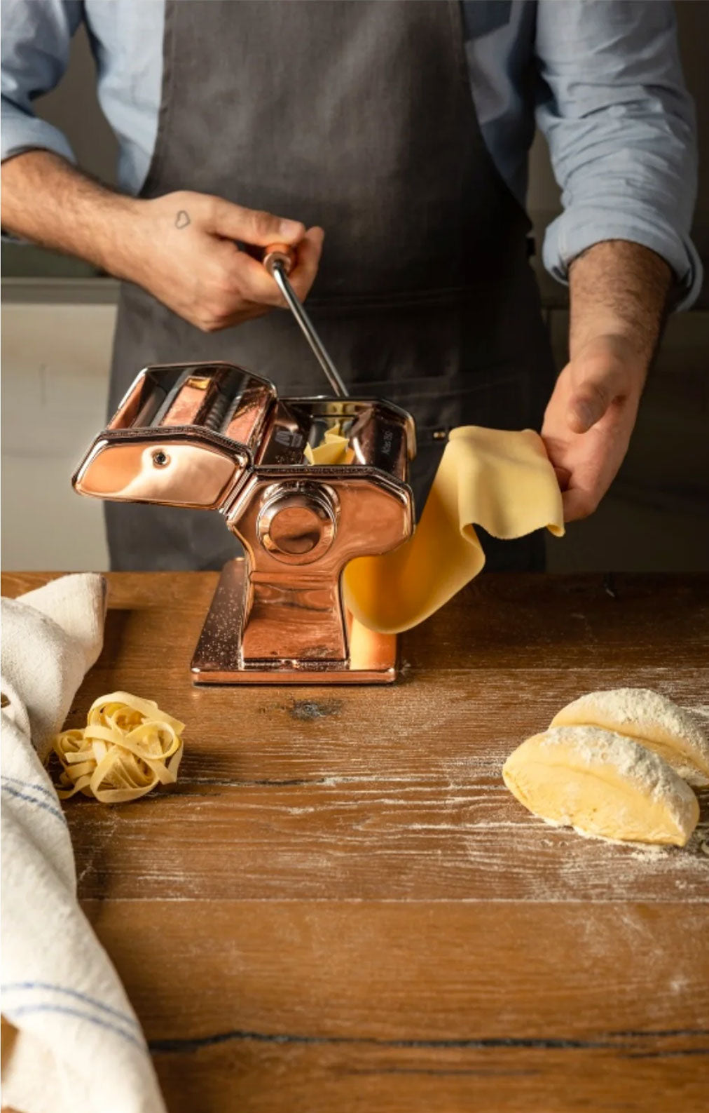 A man is making pasta with a pasta maker.