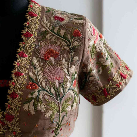 A close-up photo showcasing exquisite hand-embroidered floral motifs on a Paithani blouse.