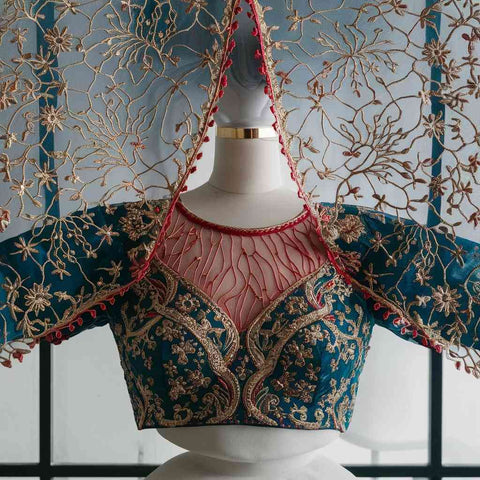 A photo of a Paithani blouse featuring cutwork details, creating a delicate and sheer effect.