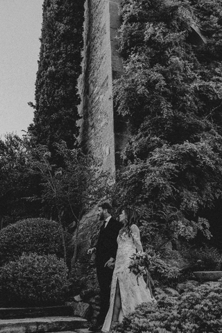 Black and white photograph of the couple from afar, standing and holding hands