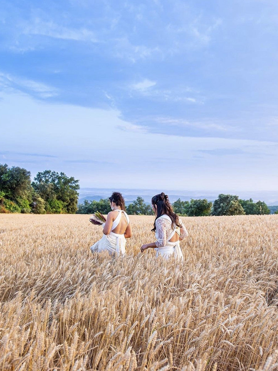 Two brides who just got married in a beautiful rustic setting: a wheat field