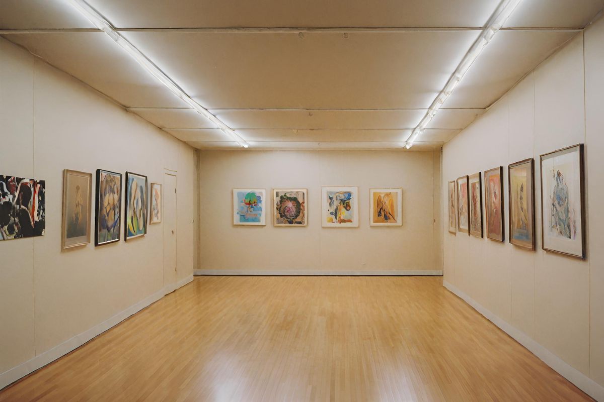 A room illuminated by track lighting, highlighting several art pieces
