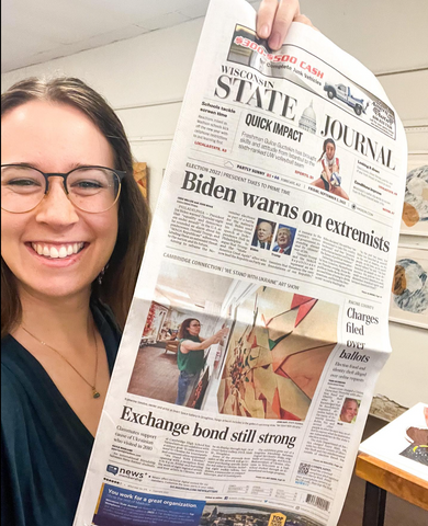 Katherine Simdon from Overt Space Gallery + Gift in Stoughton, WI holding Wisconsin State Journal. Overt Space Gallery + Gift featured on front page of Wisconsin State Journal for Ukraine Benefit. 