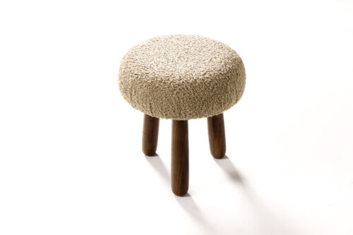A beautifully styled room featuring a boucle stool as the centerpiece