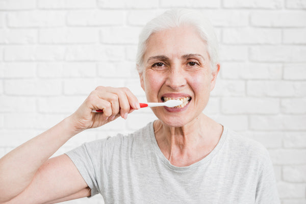 Femme âgée se brossant les dents 