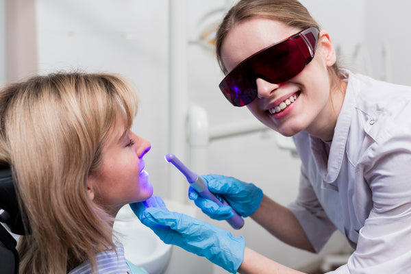 Dentiste effectuant un blanchiment dentaire