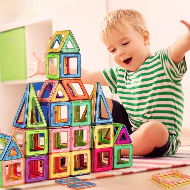Criança animada brincando com Brinquedo Educativo Bloco Magnético grandes e coloridos