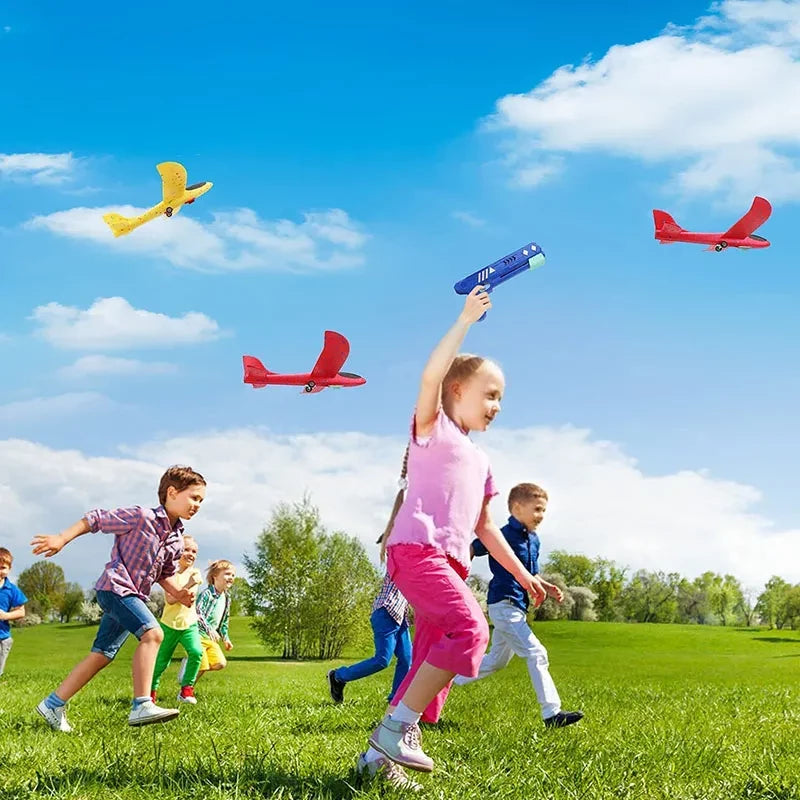 Crianças brincando ao ar livre com brinquedos de avião planador em um dia ensolarado