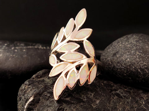 Bague grecque en argent avec feuilles d'opale blanche sur fond noir.