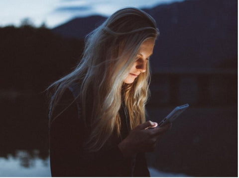 Woman Looking At Phone Receiving Blue Light Damage