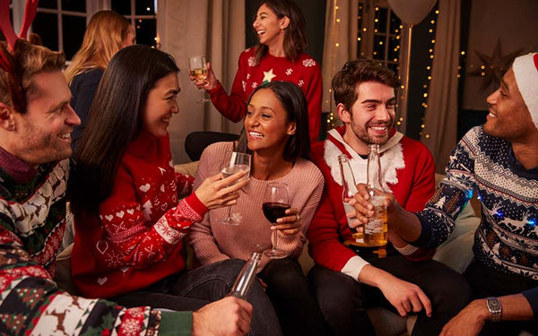 Julfest där flera personer sitter i en soffa och dricker alkohol