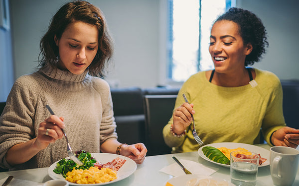 två kvinnor äter på keto-diet äter ketogen kost vid ett middagsbord