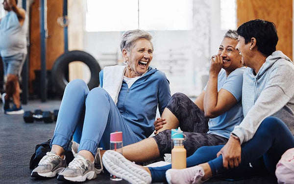 Kvinnor med en hälsosam livsstil sitter och skrattar på ett gym