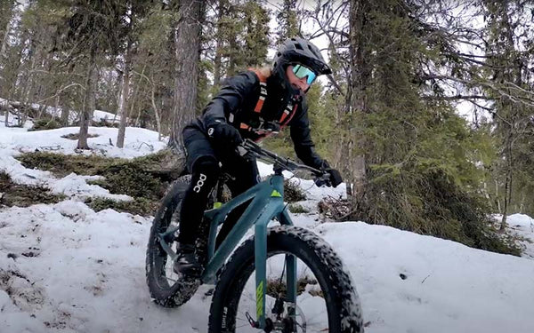 Downhillcyklist cyklar i en snöbelagd skog