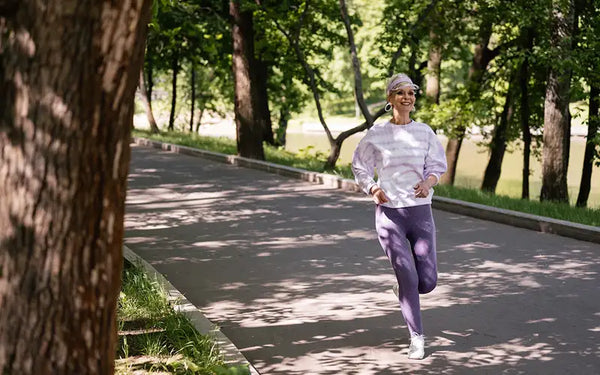 äldre kvinna med hälsosam livsstil joggar i en park